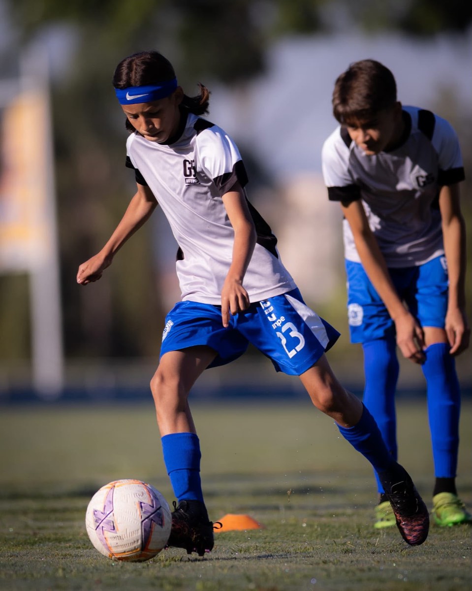 Atleta do G5 conduzindo a bola entre cones